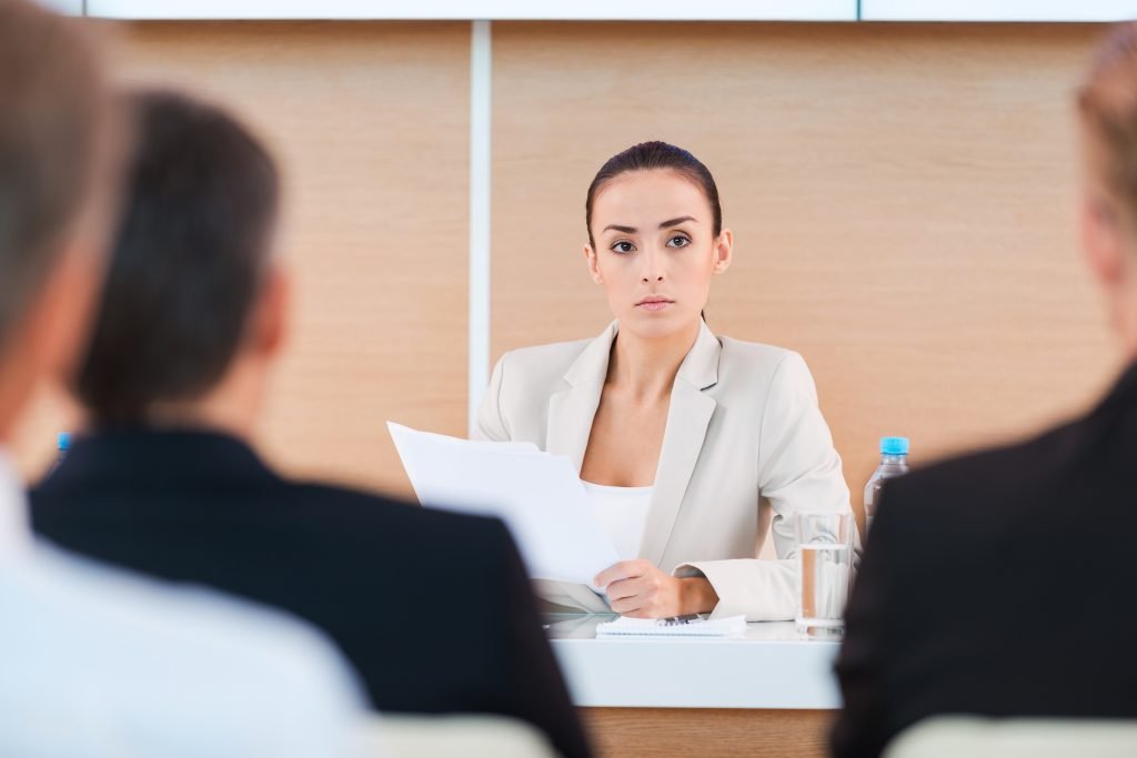 Eine erfolgreiche Business-Frau hält einen Vortrag - Einen guten LinkedIn Beitrag erstellen kann auch bedeuten über einen Berufswechsel oder Überstationen des Arbeitslebens zu berichten